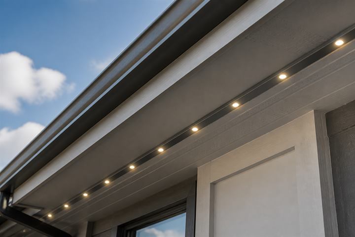 Daytime close-up of discreet roofline lighting track under a soffit.